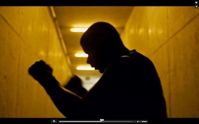 a man standing in a hallway with his fist up