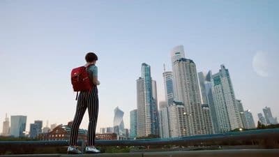a man with a red backpack is standing on a bridge