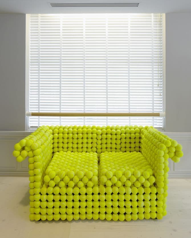 a couch made out of balls in front of a window