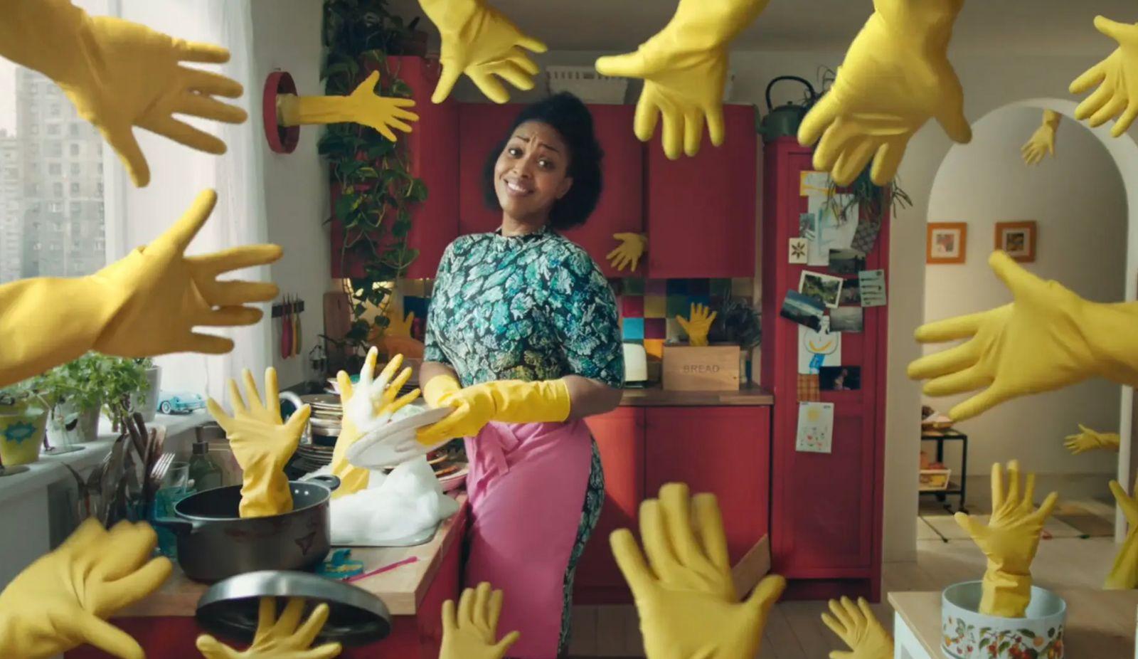 a woman standing in a kitchen surrounded by yellow hands