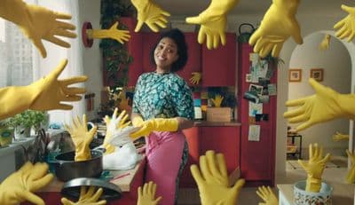 a woman standing in a kitchen surrounded by yellow hands