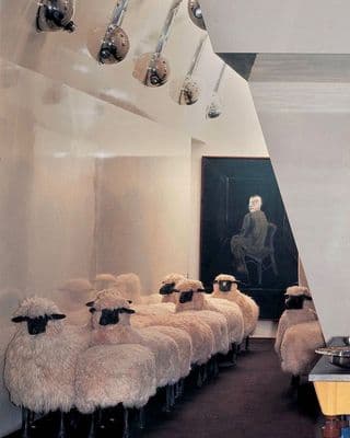 a herd of sheep are lined up in a room