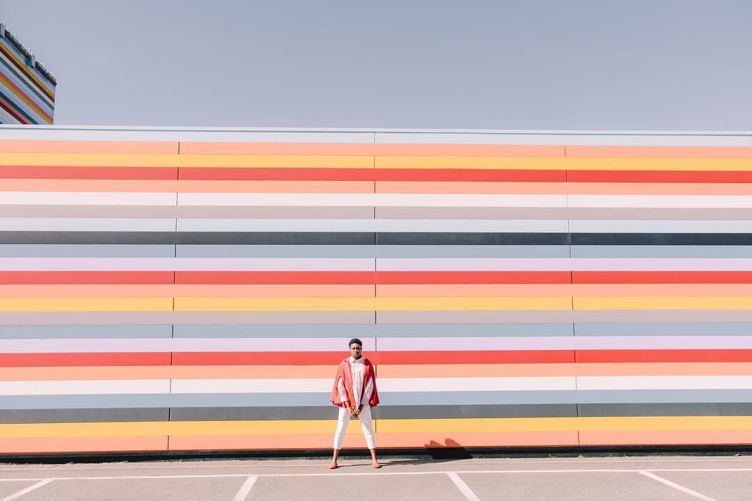 a man standing in front of a colorful wall