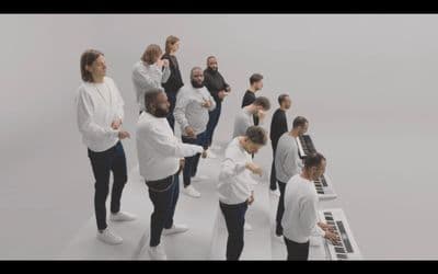 a group of people standing around a piano