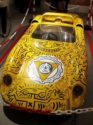a yellow race car is on display in a museum