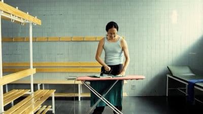 a woman ironing clothes on an ironing board