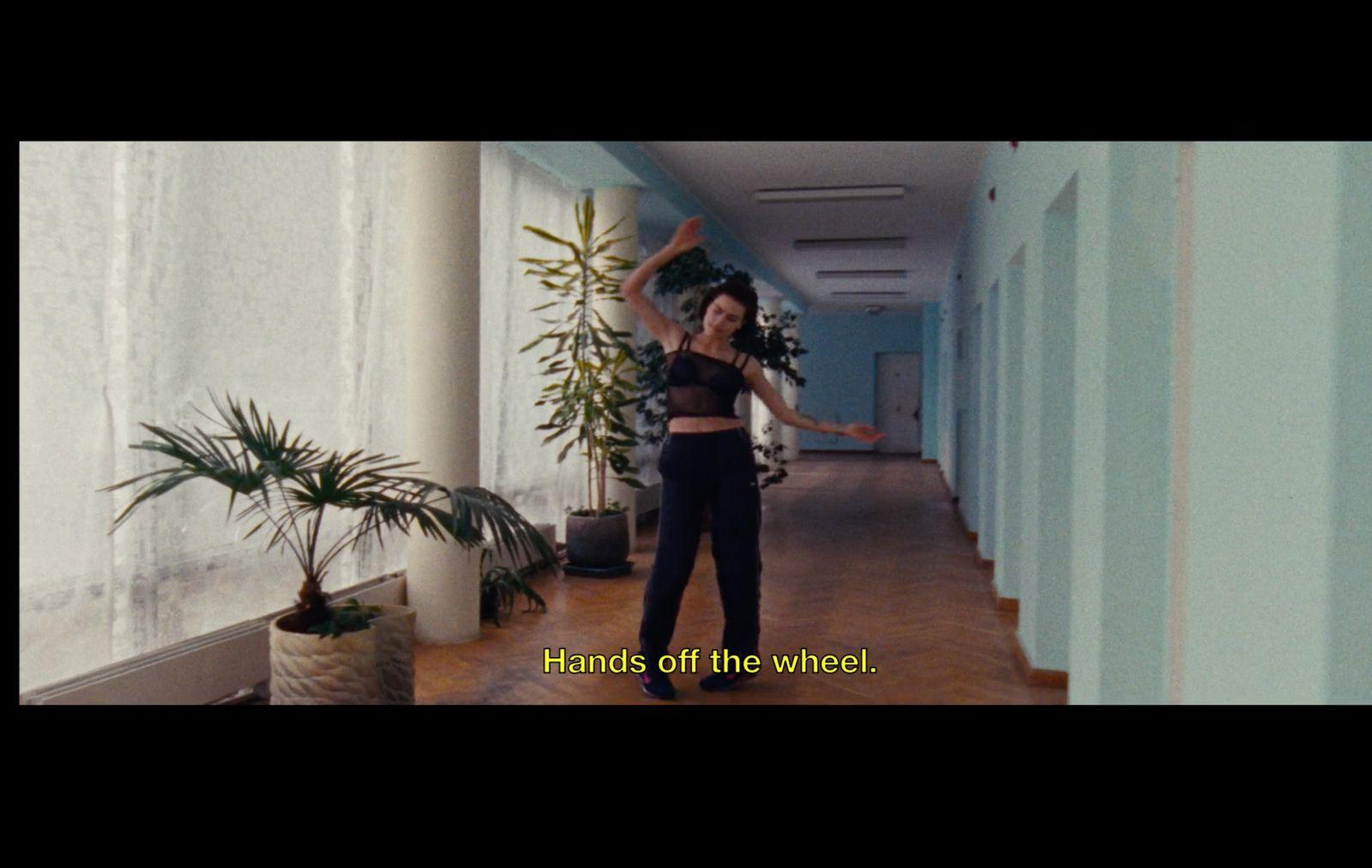 a woman standing in a hallway with her arms in the air