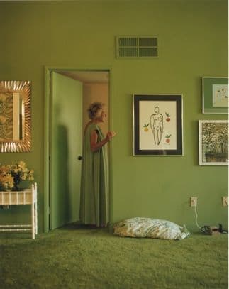 a woman standing in a room with green walls