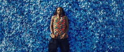 a man standing in front of a blue wall