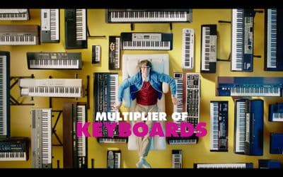 a man standing in front of a bunch of keyboards