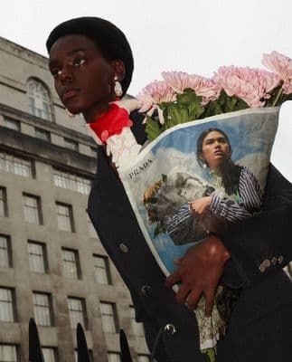 a woman holding a bouquet of flowers in front of a building