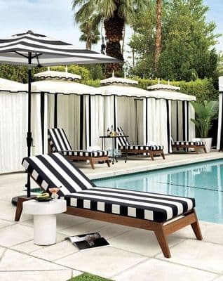 a black and white striped chaise lounge next to a pool