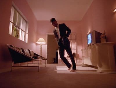 a man standing in a living room next to a tv