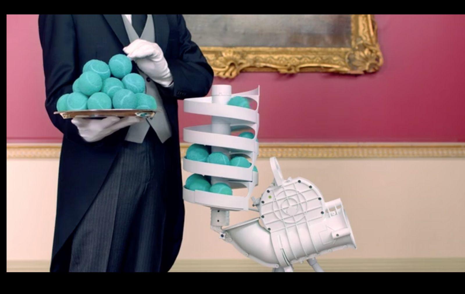 a man in a suit holding a tray of blue balls