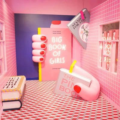 a pink room with a big book of girls on the wall