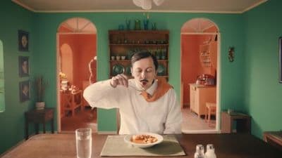 a man sitting at a table with a plate of food in front of him