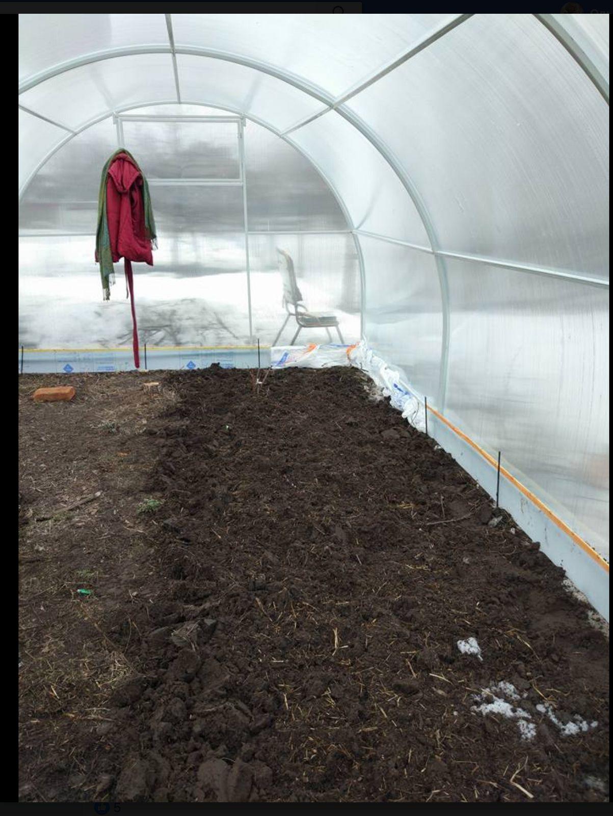 a green house with dirt inside of it