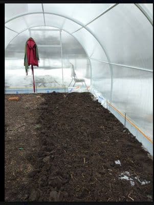a green house with dirt inside of it