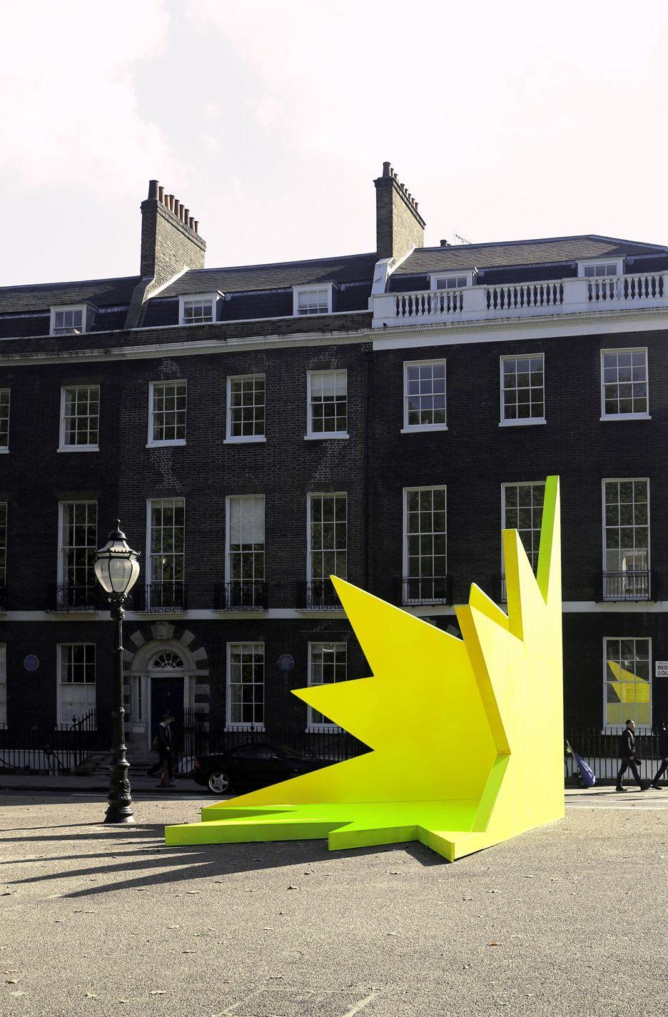a large yellow sculpture in front of a building