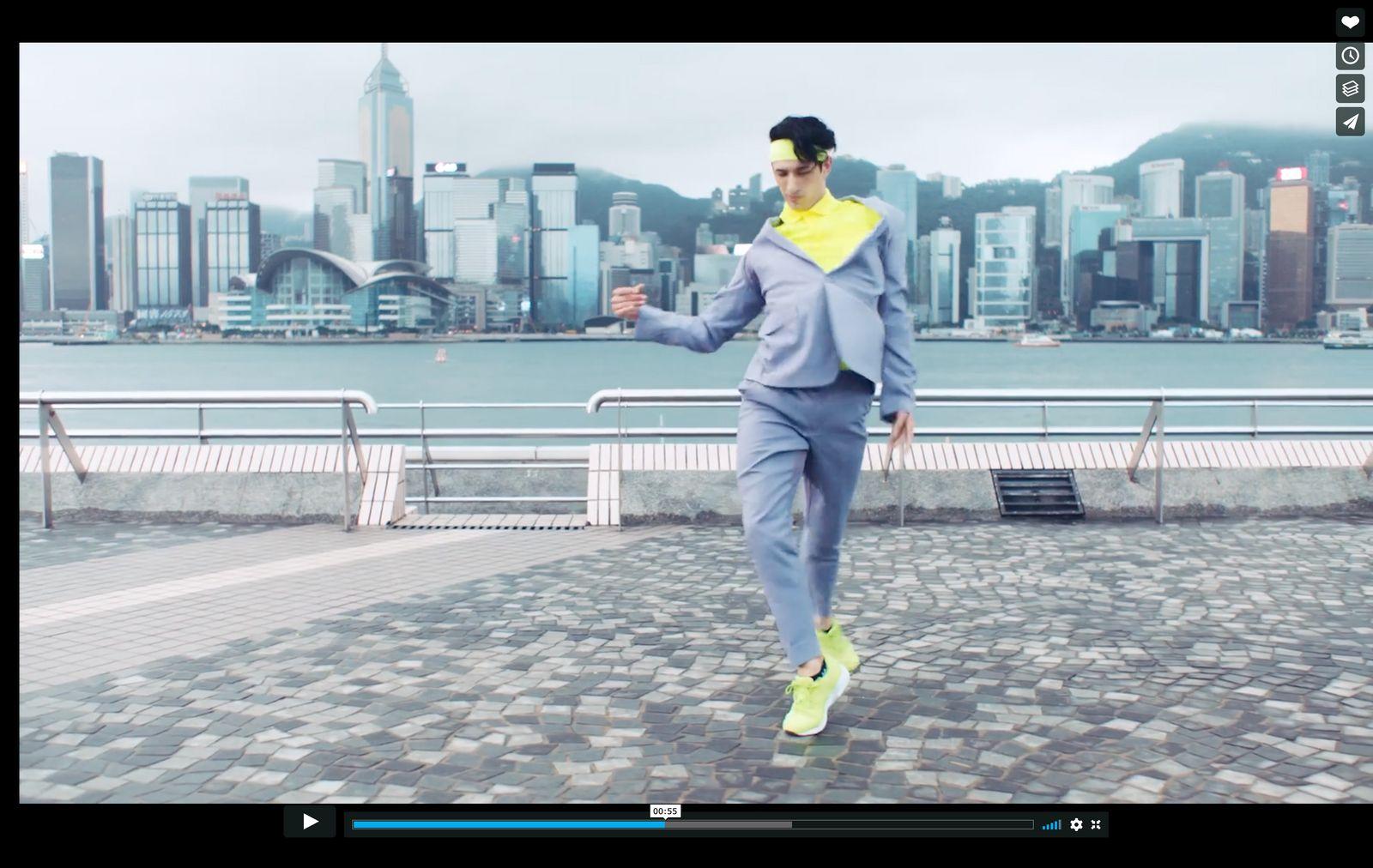 a man in a suit running on a sidewalk