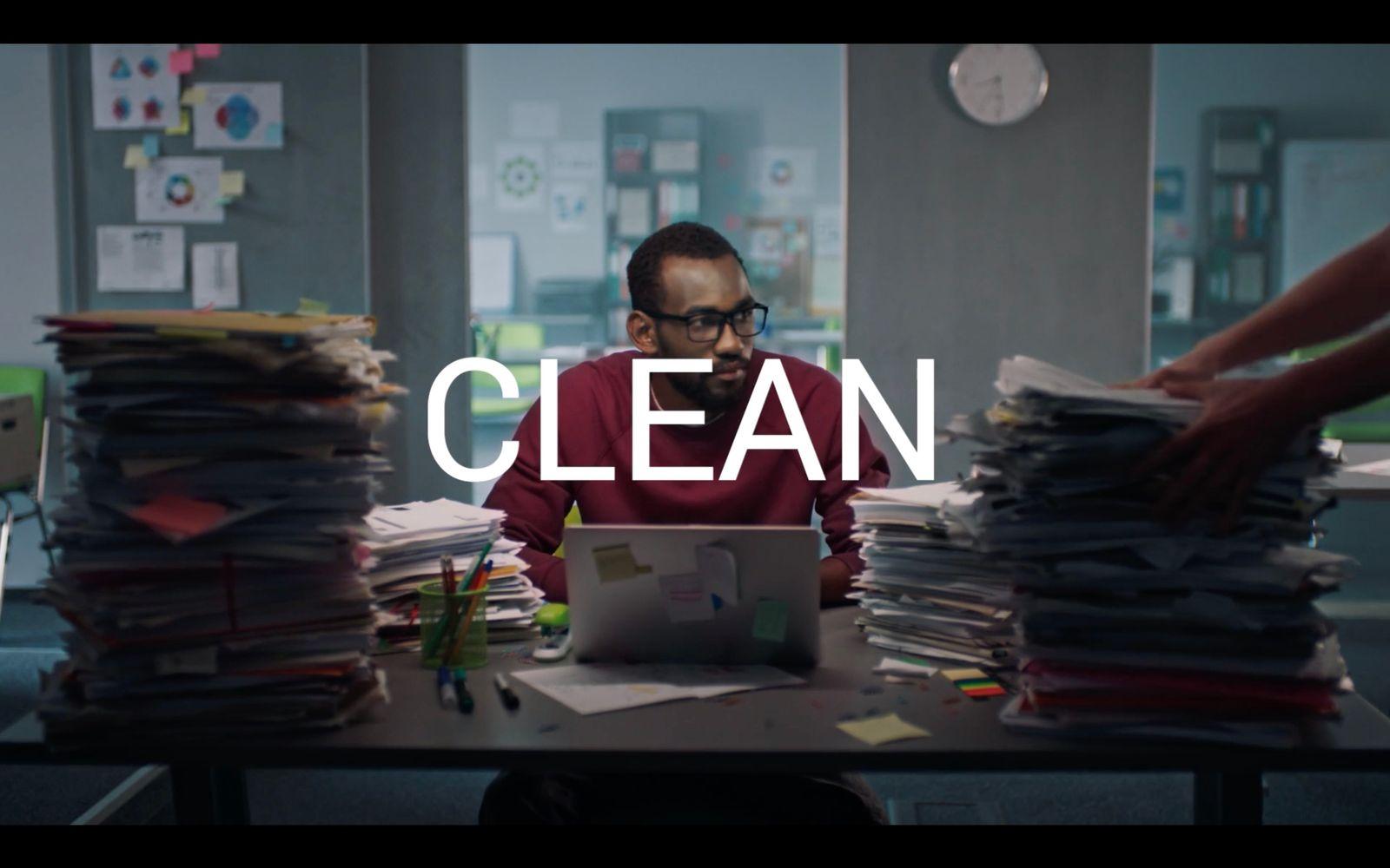 a man sitting at a desk with stacks of papers