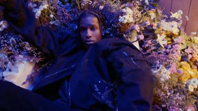 a man laying on the ground surrounded by flowers
