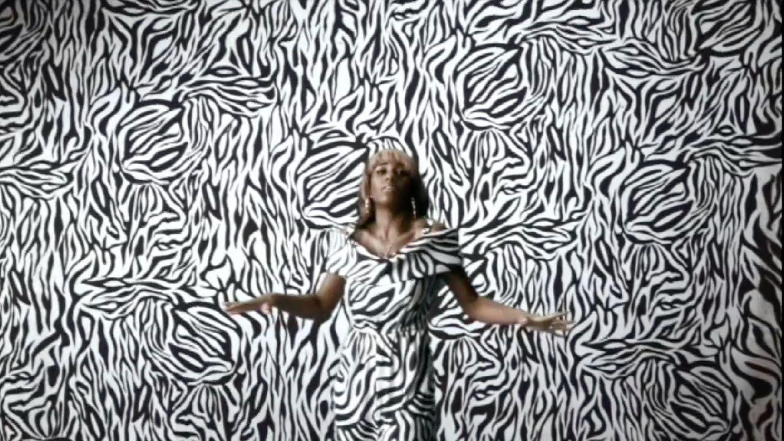 a woman standing in front of a zebra print wall