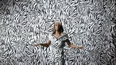 a woman standing in front of a zebra print wall