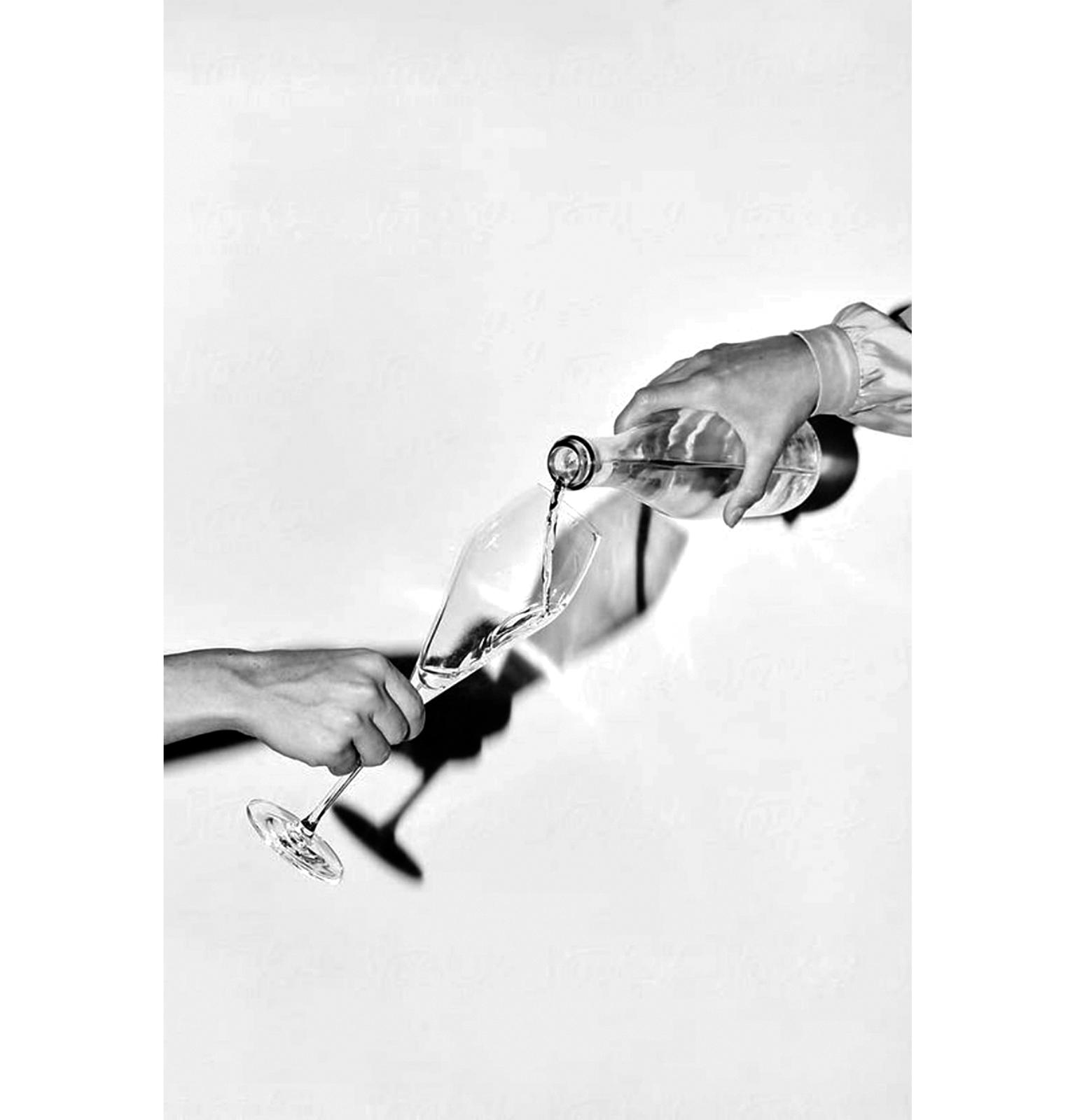 a black and white photo of two hands holding wine glasses