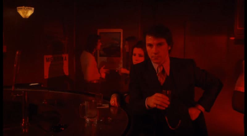 a man in a suit and tie standing in a dark room