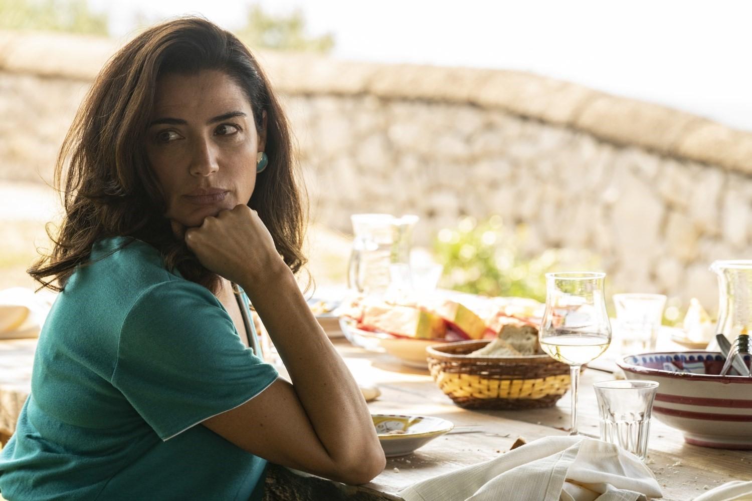 a woman sitting at a table with a plate of food