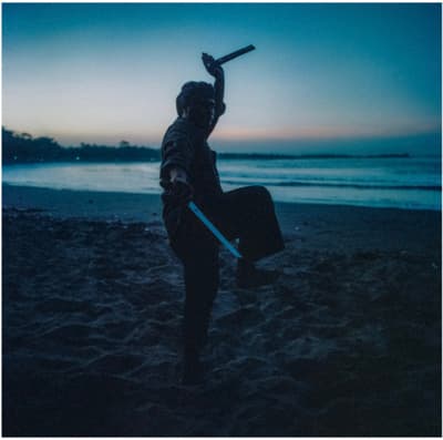 a person holding a sword on a beach