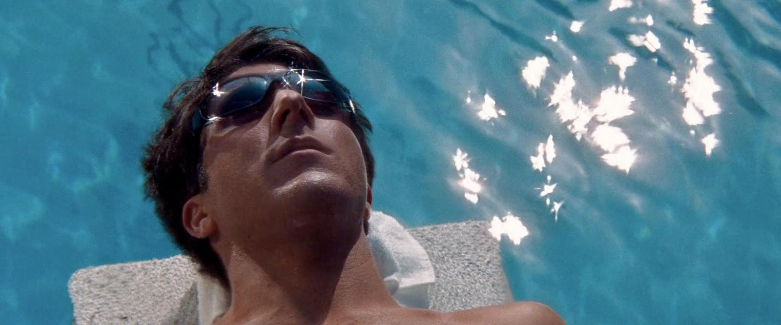 a man laying on a towel in a swimming pool