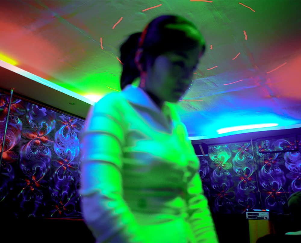a woman standing in a room next to a wall