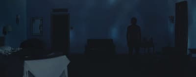 a dark room with a person standing in the corner
