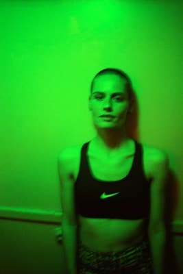 a woman standing in front of a green wall