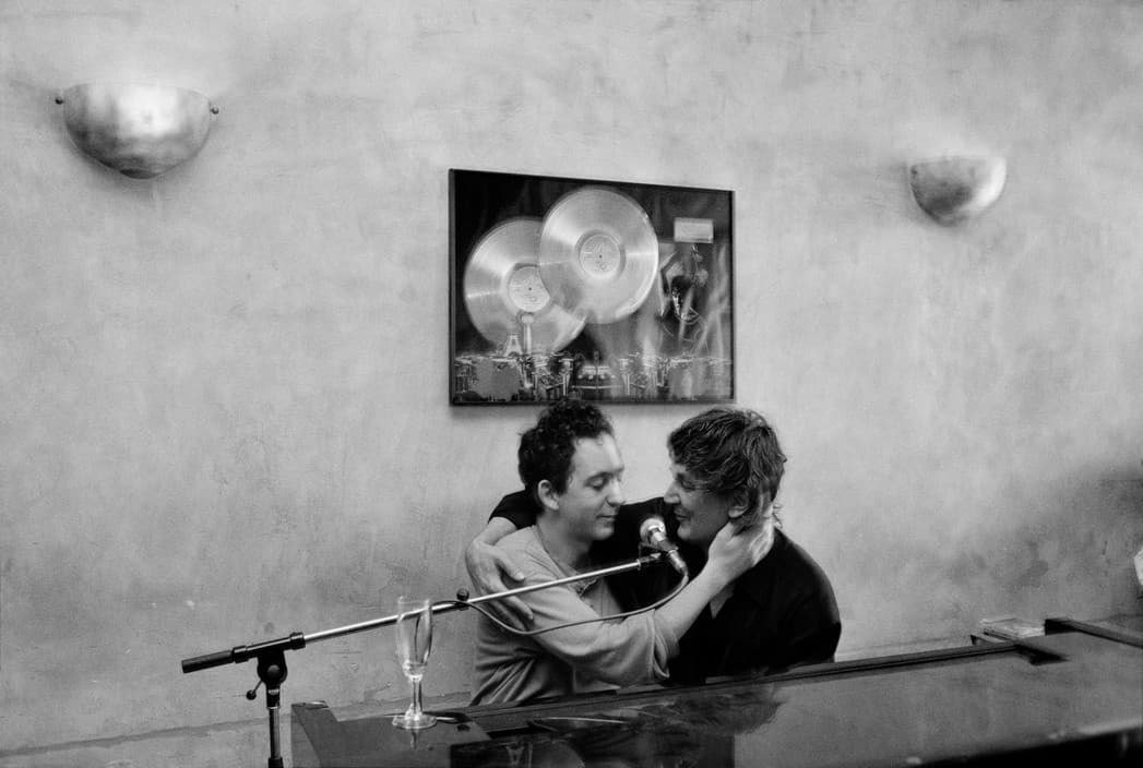 a man and a woman sitting at a piano