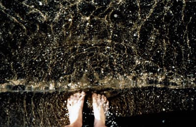 a person standing under an umbrella in the rain