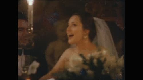 a woman in a wedding dress standing in front of a cake