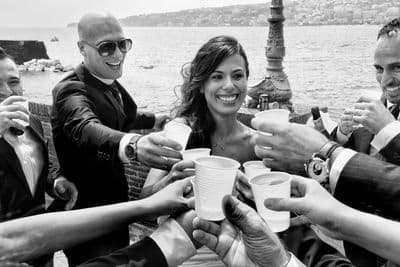 a group of people standing around each other holding cups