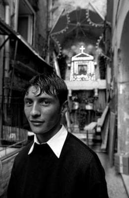 a man standing in a narrow alley way