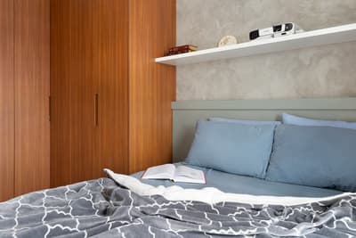 a bed with a blue comforter and a book on top of it