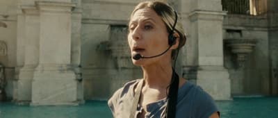 a woman wearing a headset in front of a fountain