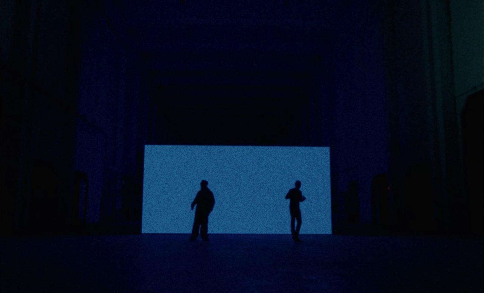 a couple of people standing in a dark room