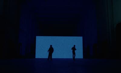 a couple of people standing in a dark room