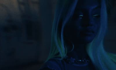 a woman with long blonde hair in a dark room