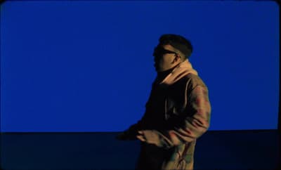 a man standing in front of a blue background
