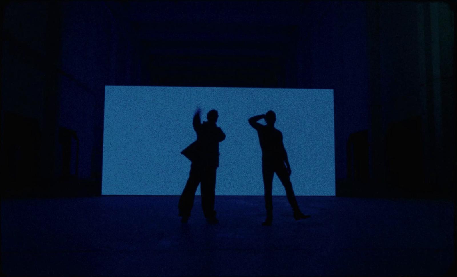 a couple of people that are standing in the dark