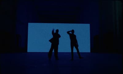 a couple of people that are standing in the dark
