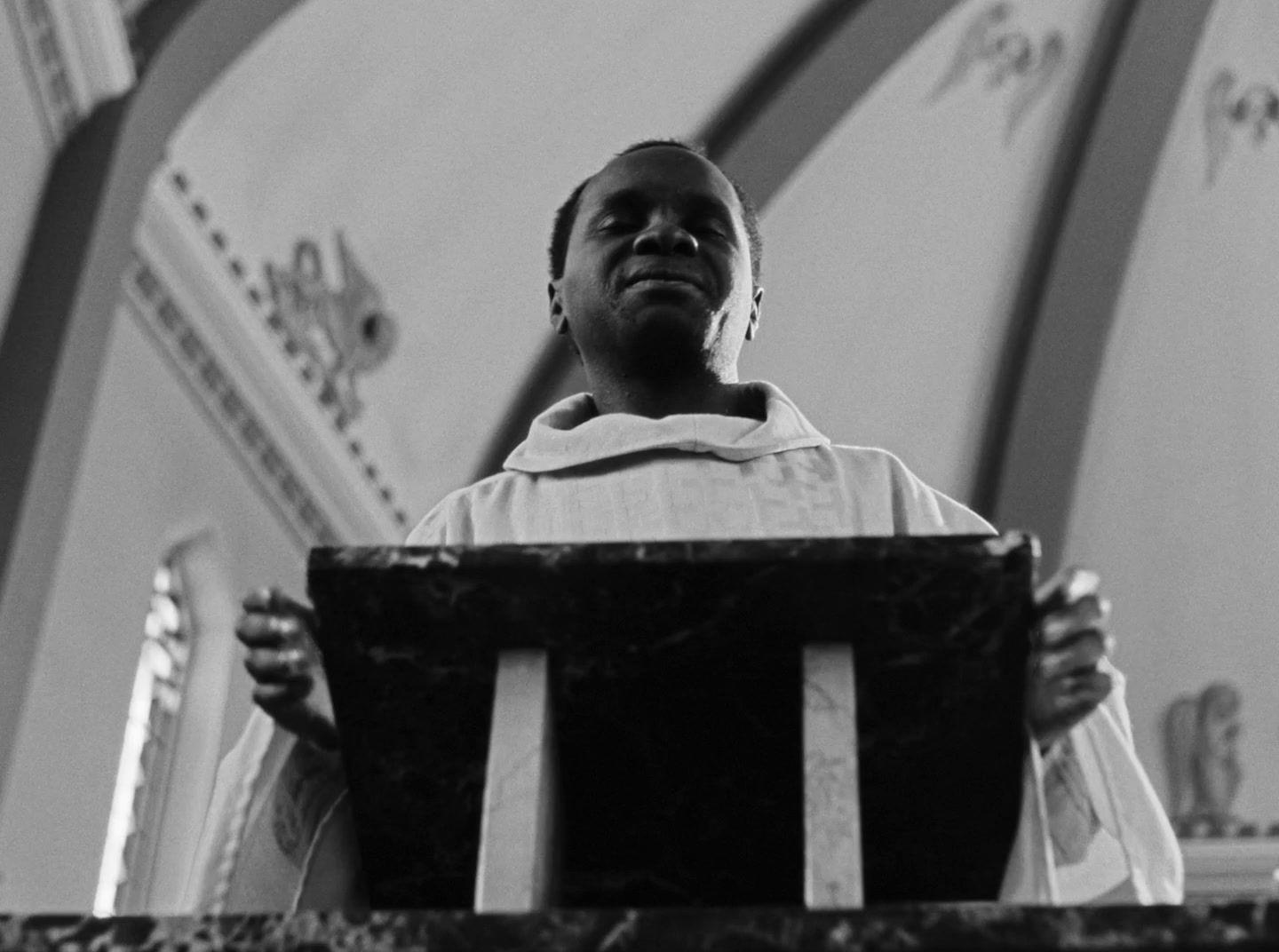 a black and white photo of a man standing at a podium